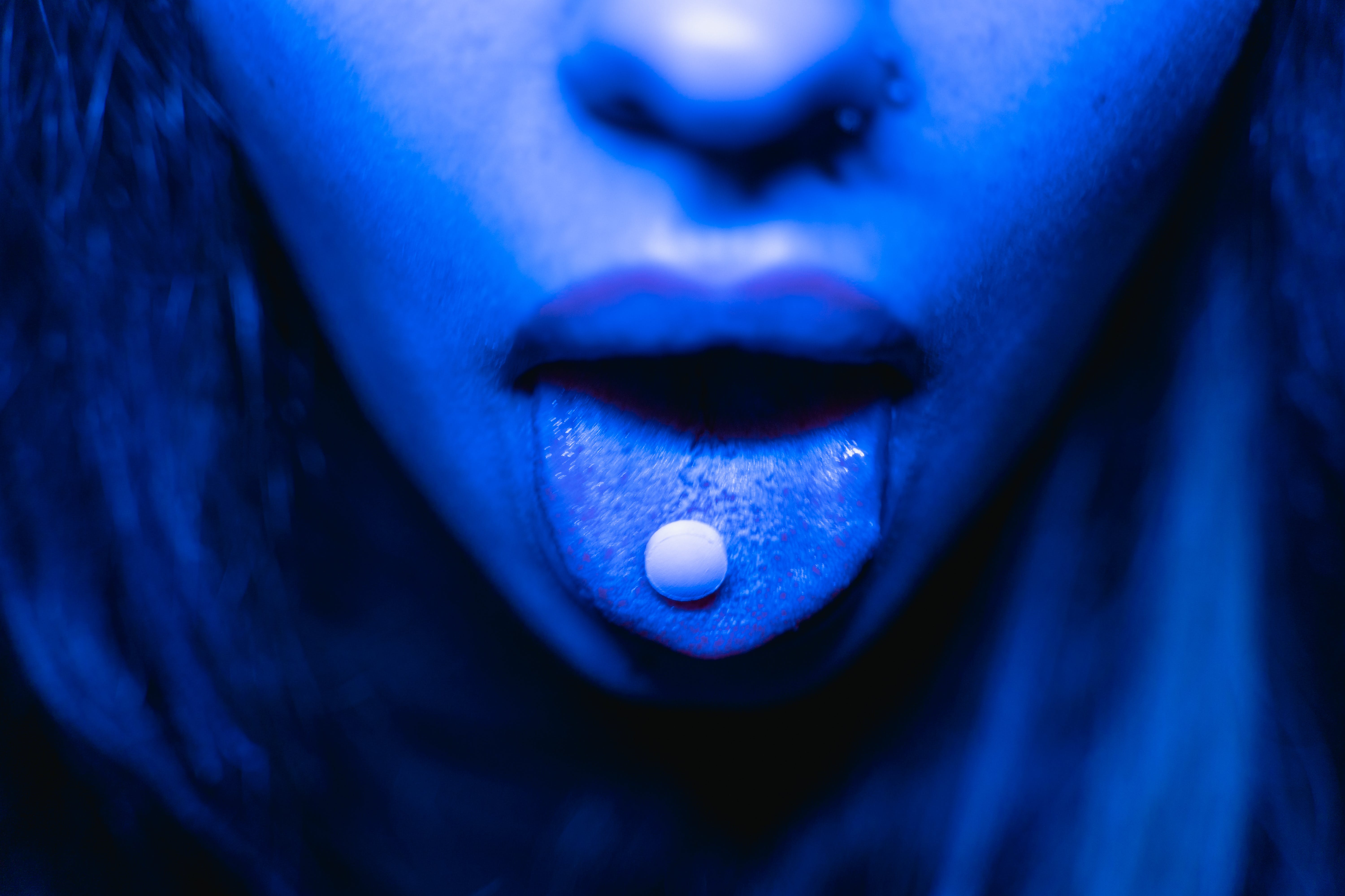 Woman with pills on her tongue